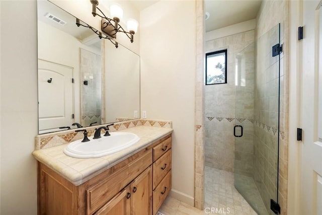 bathroom with tile patterned floors, vanity, and a shower with shower door