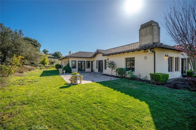 rear view of property with a patio area and a lawn