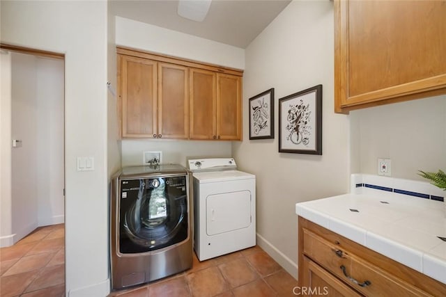 washroom with washer and dryer, cabinets, and light tile patterned floors