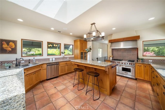 kitchen with a center island, a kitchen breakfast bar, decorative backsplash, appliances with stainless steel finishes, and light stone counters