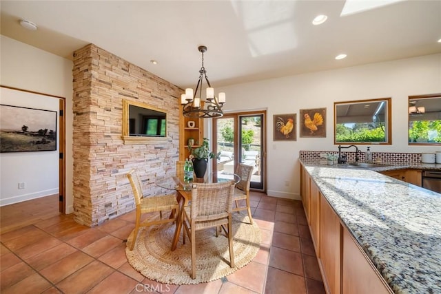 tiled dining area with sink and a chandelier