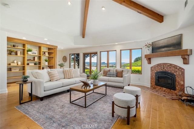 living room featuring lofted ceiling with beams and light hardwood / wood-style flooring