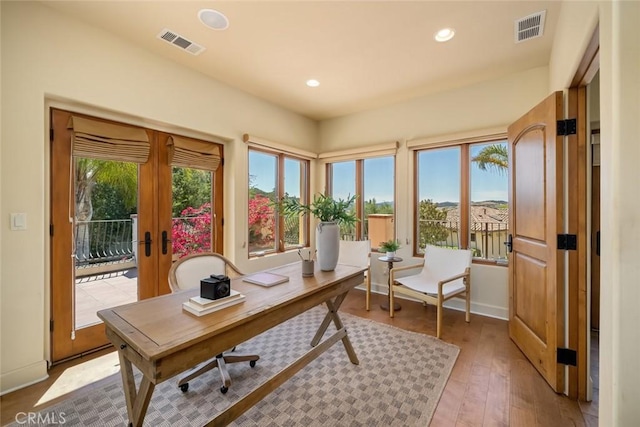 office area featuring a wealth of natural light, french doors, and light wood-type flooring