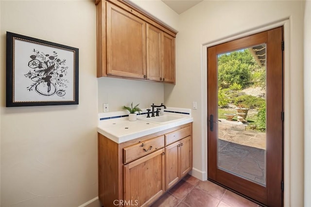 interior space with dark tile patterned floors and sink