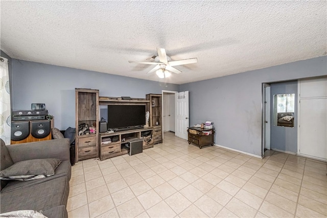 living room featuring ceiling fan and a textured ceiling