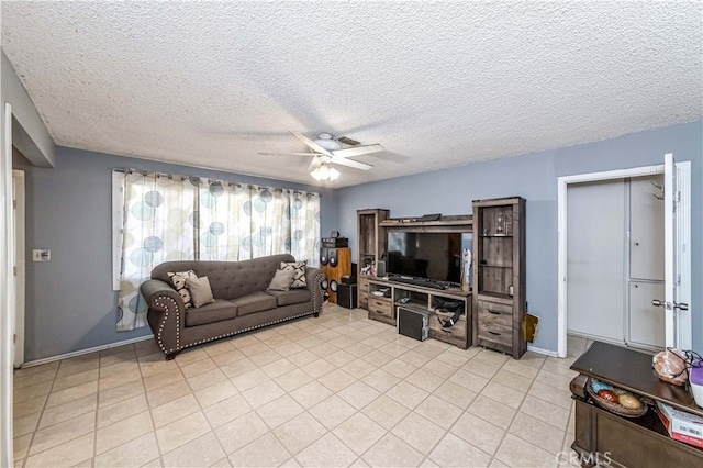 living room with ceiling fan and a textured ceiling