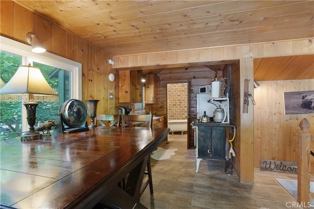 dining room featuring wooden ceiling and wooden walls