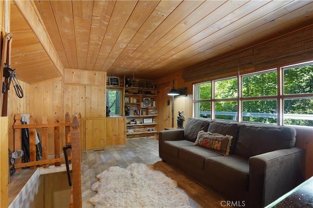 living room featuring wood-type flooring, built in features, wood ceiling, and wooden walls