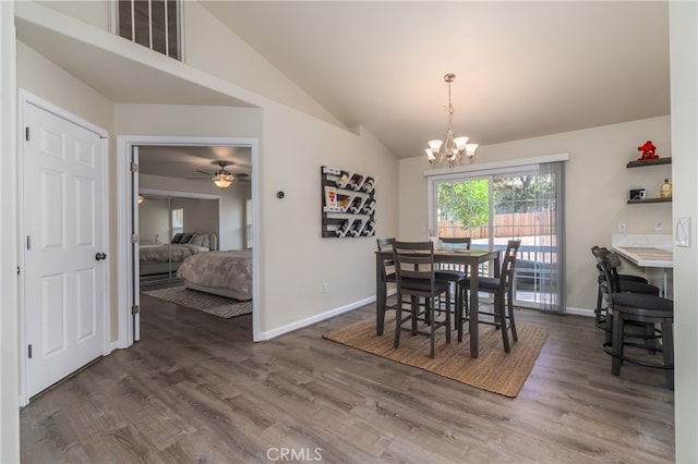 dining room featuring vaulted ceiling, ceiling fan with notable chandelier, and dark hardwood / wood-style flooring