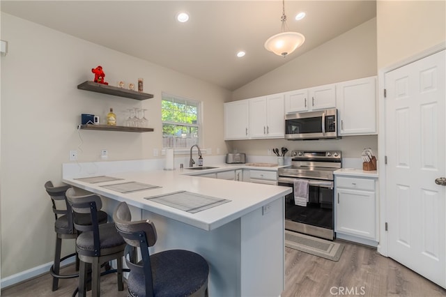 kitchen featuring white cabinetry, kitchen peninsula, and appliances with stainless steel finishes