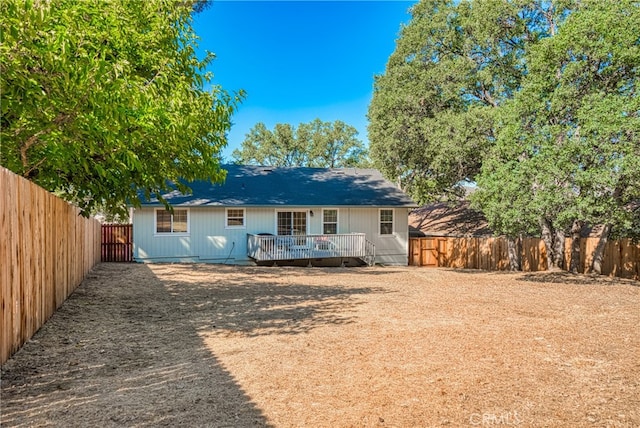 back of house with a deck