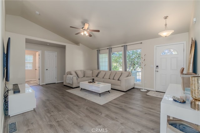 living room featuring a wealth of natural light, vaulted ceiling, ceiling fan, and hardwood / wood-style floors