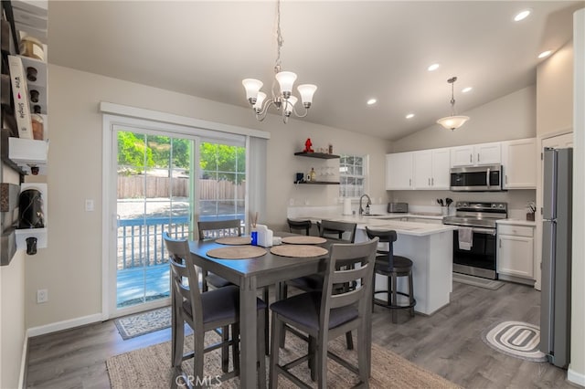 dining space with vaulted ceiling, dark hardwood / wood-style flooring, and a chandelier