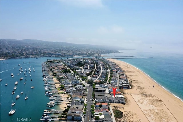 birds eye view of property with a water view and a beach view