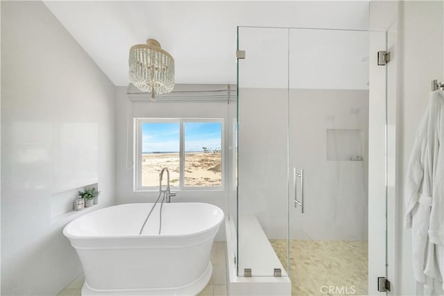 bathroom featuring a chandelier, shower with separate bathtub, vaulted ceiling, and tile patterned floors