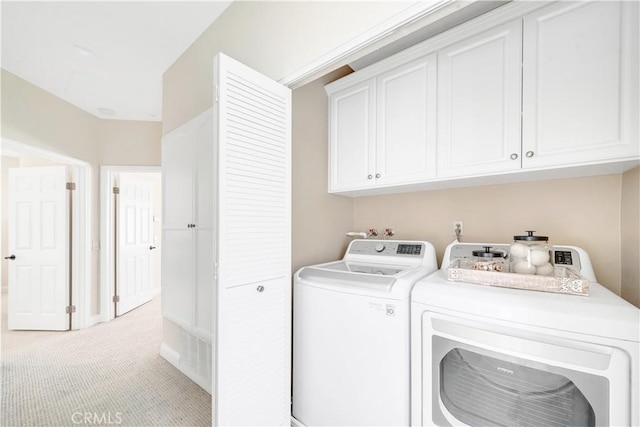 washroom featuring cabinets, independent washer and dryer, and light carpet