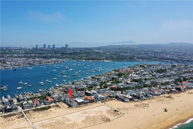 birds eye view of property with a water view and a beach view