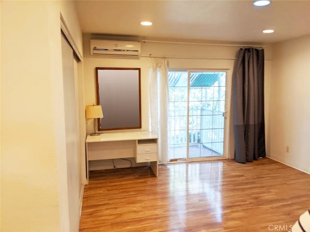 interior space with light hardwood / wood-style flooring and a wall mounted air conditioner