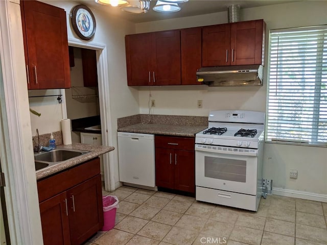 kitchen featuring white appliances, light tile patterned flooring, a healthy amount of sunlight, and sink