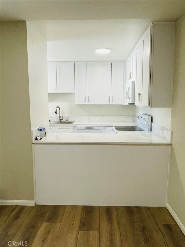 kitchen featuring white cabinets, white appliances, and dark wood-type flooring