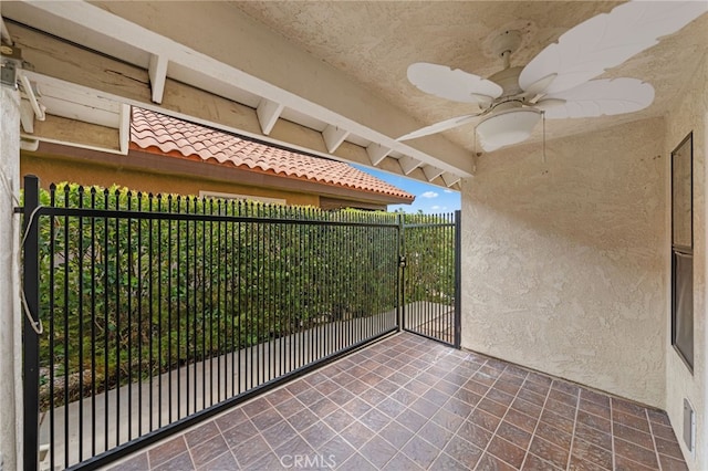 unfurnished sunroom featuring ceiling fan