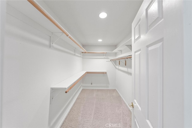 walk in closet featuring light carpet