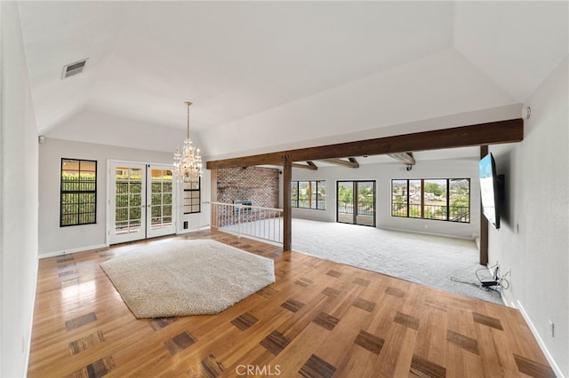 unfurnished living room featuring carpet, plenty of natural light, lofted ceiling with beams, and a chandelier