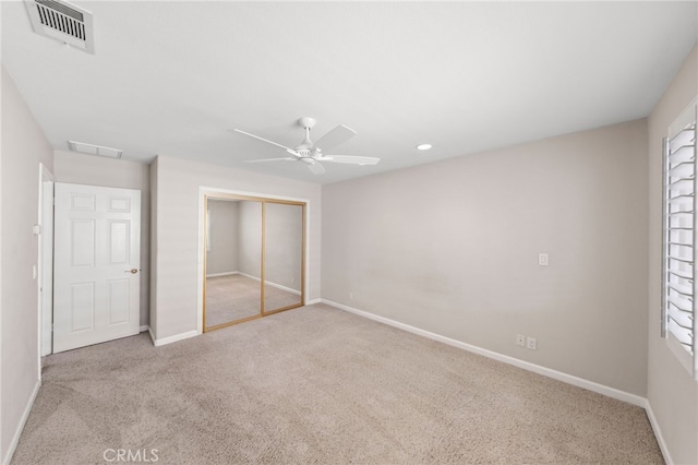 unfurnished bedroom with ceiling fan, light colored carpet, and a closet