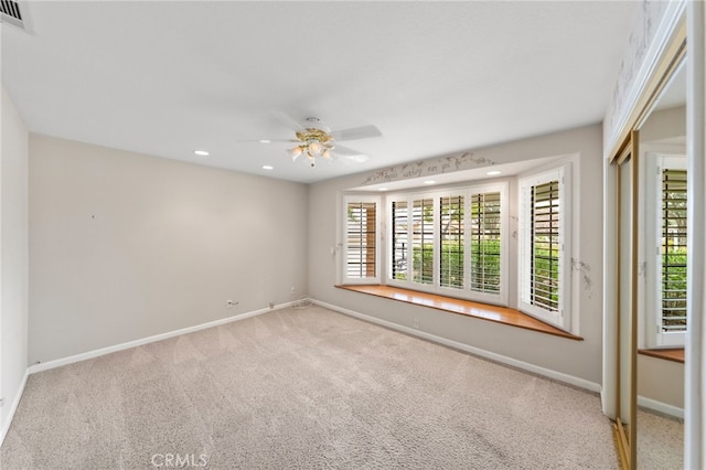 spare room featuring ceiling fan and light colored carpet