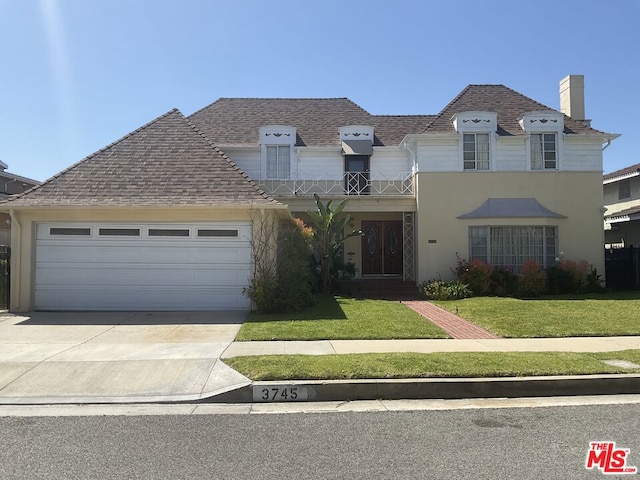 view of front of home with a garage and a front lawn