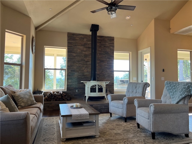 living room featuring a wood stove, hardwood / wood-style floors, ceiling fan, and a wealth of natural light