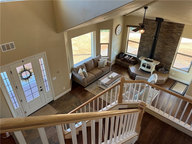 living room with a wood stove, a high ceiling, and dark hardwood / wood-style flooring