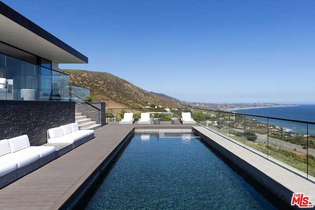 view of swimming pool with a water and mountain view