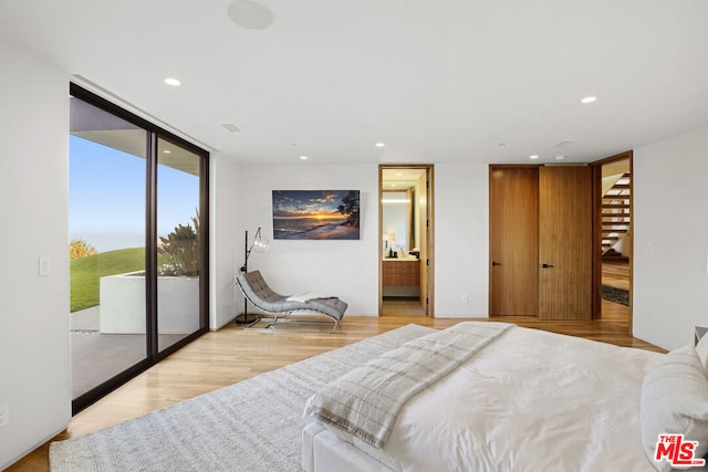 bedroom with floor to ceiling windows, ensuite bathroom, light wood-type flooring, and access to outside