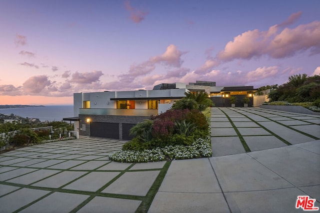 contemporary home featuring a garage and a water view