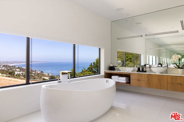 bathroom featuring vanity, a tub, tile patterned floors, and a water view