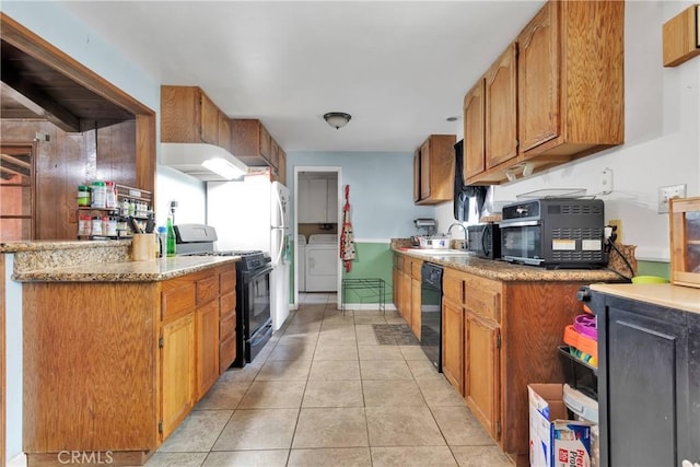 kitchen with washing machine and dryer, sink, light tile patterned floors, and black appliances