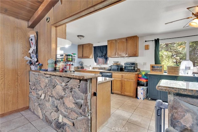 kitchen featuring ceiling fan, kitchen peninsula, wooden walls, light tile patterned floors, and black appliances