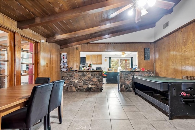 interior space with vaulted ceiling with beams, wood walls, light tile patterned floors, and wood ceiling