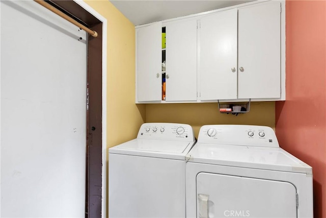 laundry room featuring cabinets and washing machine and dryer