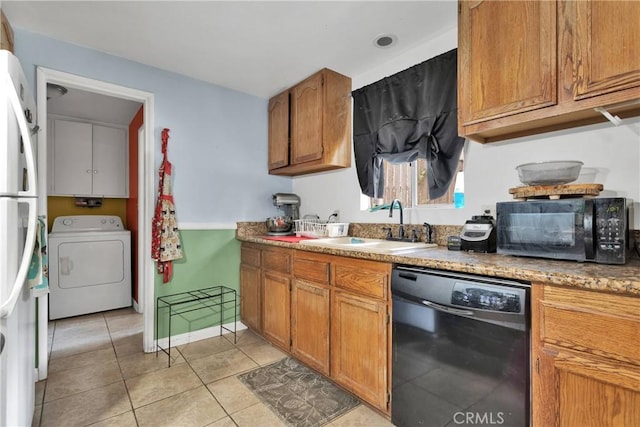 kitchen featuring washer / clothes dryer, sink, light tile patterned flooring, and black appliances