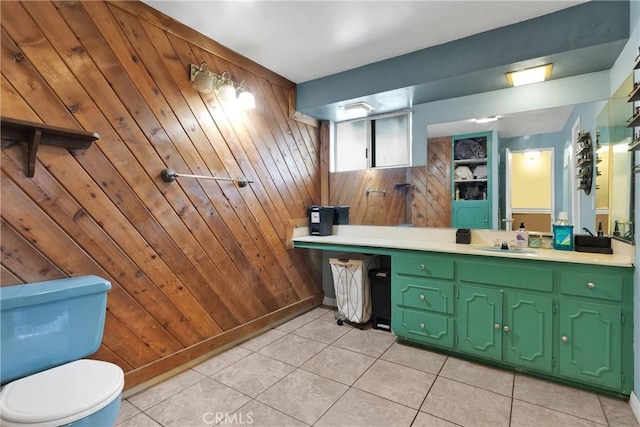 bathroom with wooden walls, tile patterned flooring, vanity, and toilet