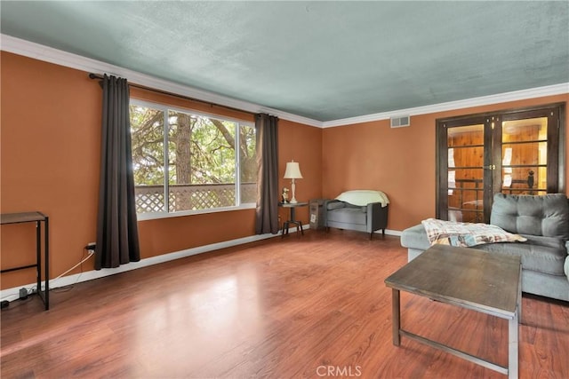 living room featuring hardwood / wood-style flooring, crown molding, and french doors