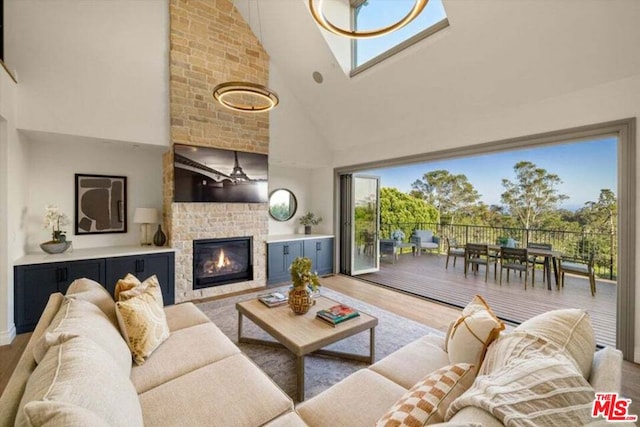 living room featuring a brick fireplace, wood-type flooring, and high vaulted ceiling