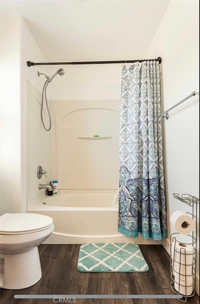 bathroom with shower / bath combination with curtain, hardwood / wood-style flooring, and toilet