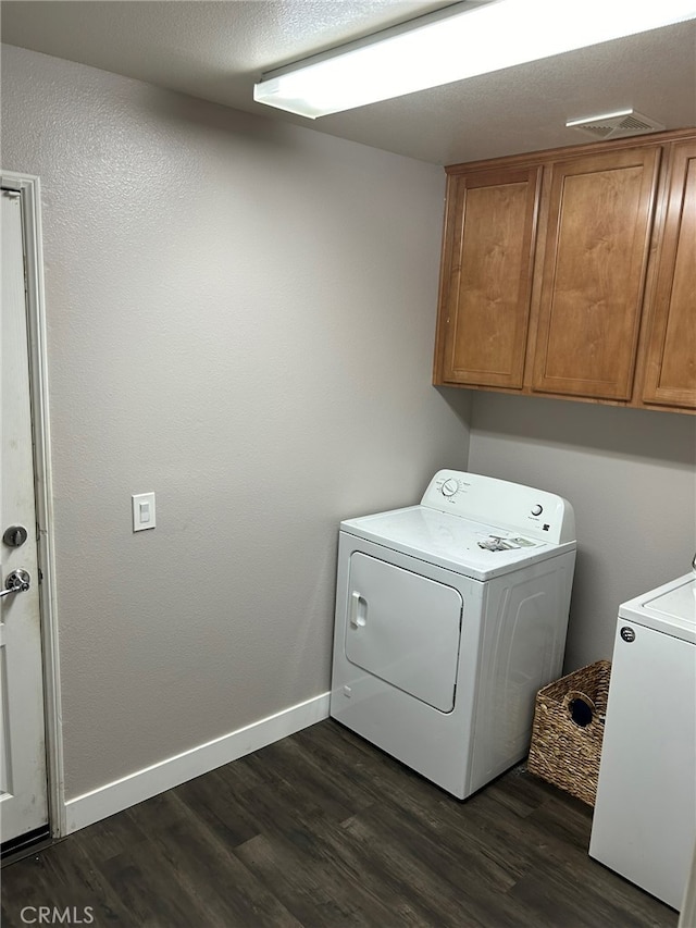 laundry area with cabinets, washer and clothes dryer, and dark hardwood / wood-style flooring