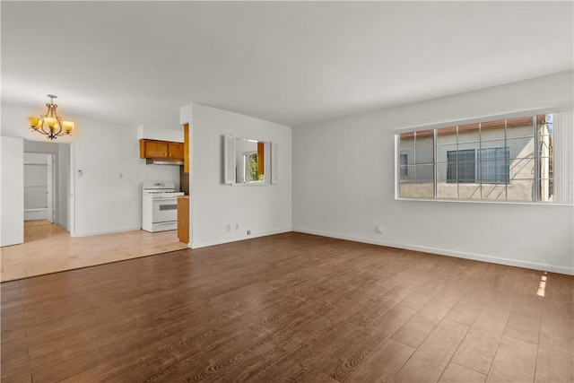 unfurnished living room featuring light hardwood / wood-style flooring and a chandelier