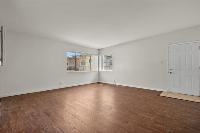 unfurnished room with dark wood-type flooring