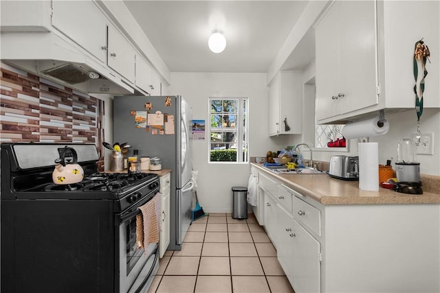 kitchen with light tile patterned floors, sink, white cabinets, and gas stove