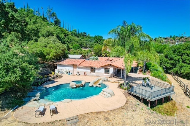 view of swimming pool with a wooden deck, an in ground hot tub, and a patio